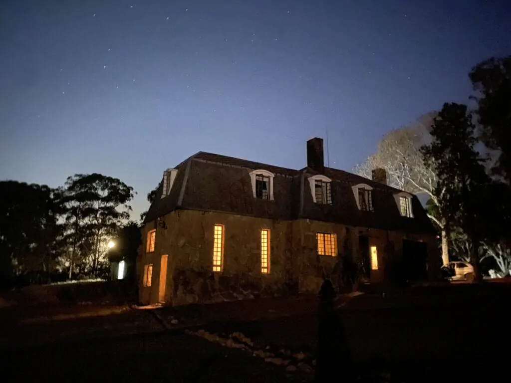 Foto da Casa de Pedra com as luzes acesas após o anoitecer